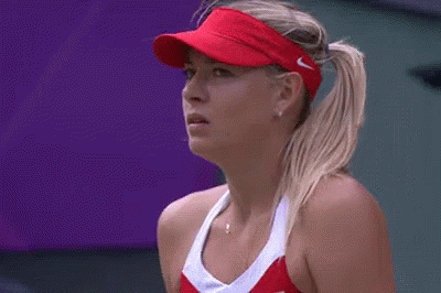 A Close Up Of A Woman Wearing A Red Visor And A Red Tennis Outfit . GIF