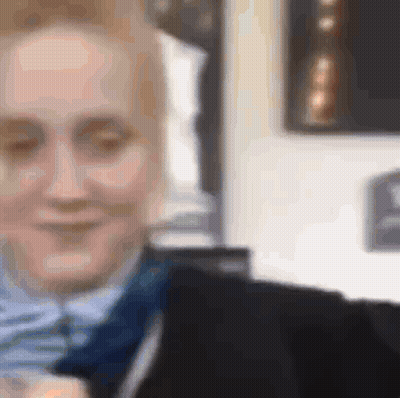 A Close Up Of A Woman Wearing A Suit And Tie Smiling . GIF