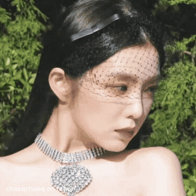 A Close Up Of A Woman Wearing A Veil And A Choker Necklace . GIF