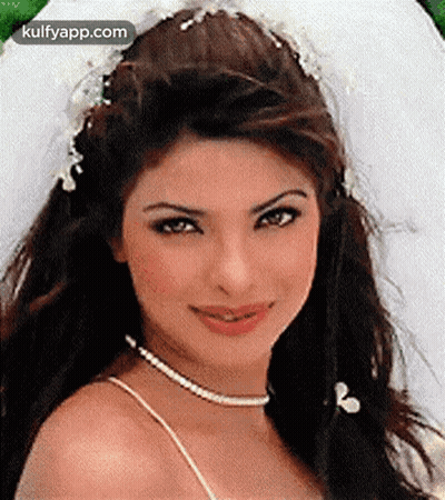 A Close Up Of A Woman Wearing A White Dress And A Veil . GIF