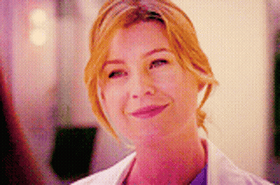 A Close Up Of A Woman Wearing A White Lab Coat And Smiling . GIF