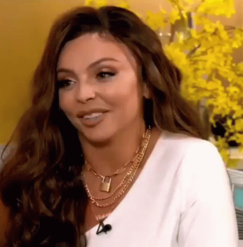 A Close Up Of A Woman Wearing A White Shirt And A Necklace . GIF