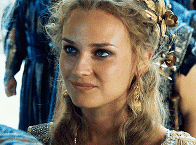 A Close Up Of A Woman Wearing A Wreath Of Gold Leaves In Her Hair GIF