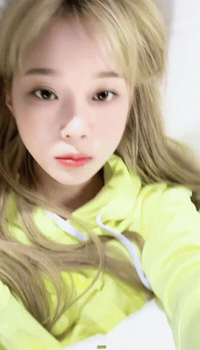 A Close Up Of A Woman Wearing A Yellow Hoodie . GIF