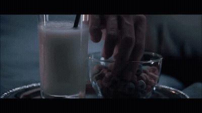 A Close Up Of A Woman Wearing Ear Buds In A Dark Room GIF