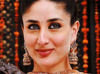 A Close Up Of A Woman Wearing Earrings And A Bindi GIF