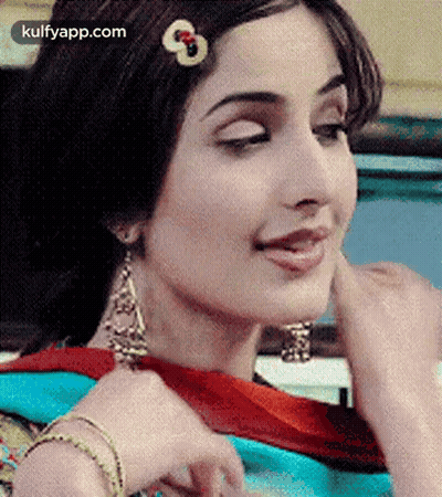 A Close Up Of A Woman Wearing Earrings And A Hair Clip . GIF
