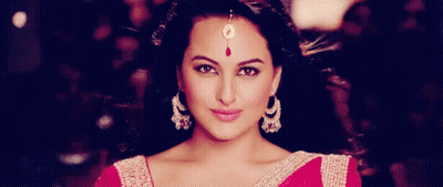A Close Up Of A Woman Wearing Earrings And A Maang Tikka . GIF