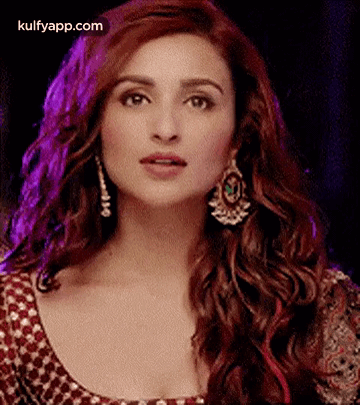 A Close Up Of A Woman Wearing Earrings And A Red Dress . GIF