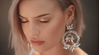 A Close Up Of A Woman Wearing Earrings GIF