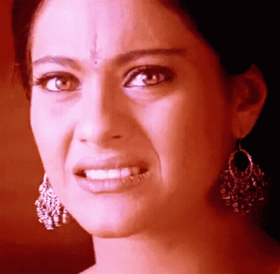 A Close Up Of A Woman Wearing Earrings Making A Face GIF