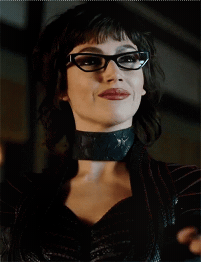 A Close Up Of A Woman Wearing Glasses And A Black Choker GIF