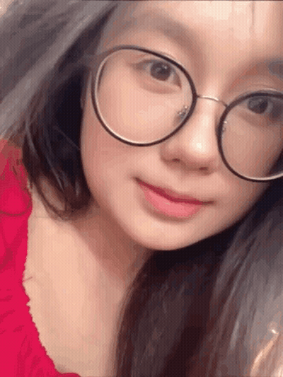 A Close Up Of A Woman Wearing Glasses And A Red Dress . GIF