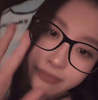 A Close Up Of A Woman Wearing Glasses With The Letter M Visible GIF
