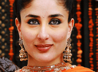 A Close Up Of A Woman Wearing Gold Earrings GIF