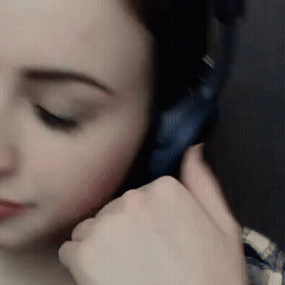 A Close Up Of A Woman Wearing Headphones With Her Eyes Closed GIF