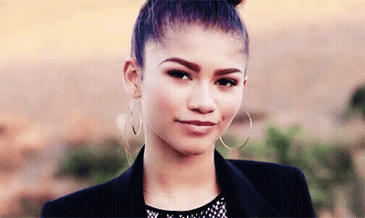 A Close Up Of A Woman Wearing Hoop Earrings And A Jacket GIF