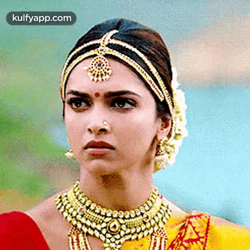 A Close Up Of A Woman Wearing Jewelry And A Headpiece . GIF