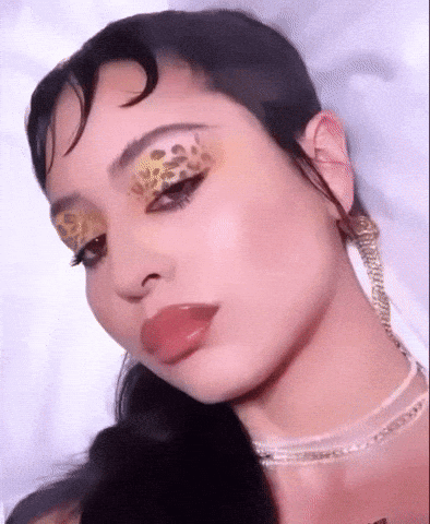 A Close Up Of A Woman Wearing Leopard Print Eye Makeup . GIF