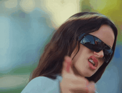 A Close Up Of A Woman Wearing Sunglasses And Making A Funny Face GIF