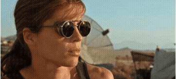 A Close Up Of A Woman Wearing Sunglasses In A Desert . GIF
