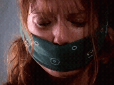 A Close Up Of A Woman With A Bandana Around Her Mouth . GIF
