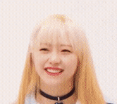 A Close Up Of A Woman With Blonde Hair And A Choker Smiling . GIF