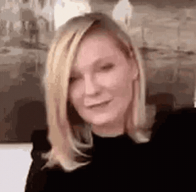 A Close Up Of A Woman With Blonde Hair Wearing A Black Shirt . GIF