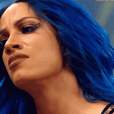 A Close Up Of A Woman With Blue Hair And A Piercing In Her Eye GIF