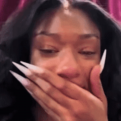A Close Up Of A Woman With Long Nails Covering Her Mouth With Her Hand . GIF