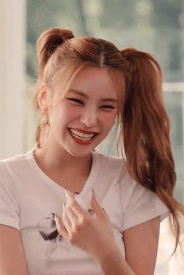 A Close Up Of A Woman With Pigtails Laughing . GIF