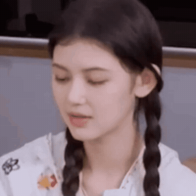 A Close Up Of A Woman With Pigtails Making A Face . GIF