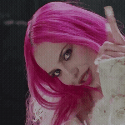 A Close Up Of A Woman With Pink Hair Covering Her Face With Her Hands . GIF