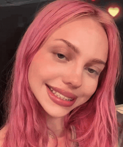 A Close Up Of A Woman With Pink Hair Smiling GIF
