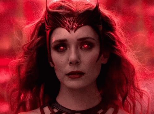 A Close Up Of A Woman With Red Eyes And A Crown On Her Head . GIF