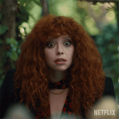 A Close Up Of A Woman With Red Hair And A Netflix Logo GIF