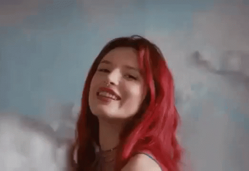 A Close Up Of A Woman With Red Hair And A Nose Ring Smiling . GIF