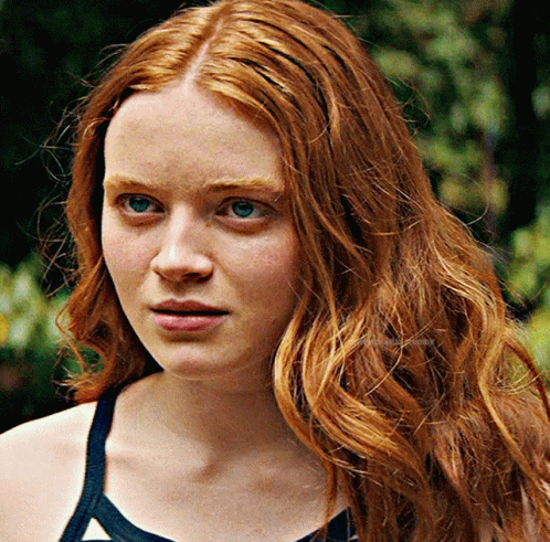 A Close Up Of A Woman With Red Hair And Blue Eyes GIF