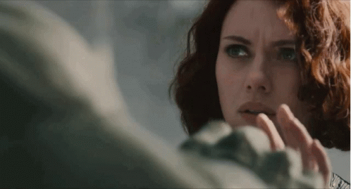 A Close Up Of A Woman With Red Hair Looking At Something GIF