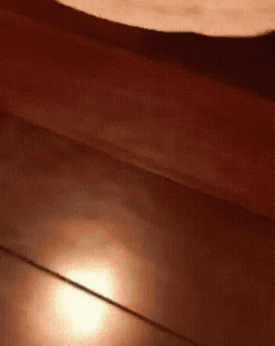 A Close Up Of A Wooden Floor With A Light Shining On It GIF