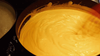 A Close Up Of A Yellow Sauce In A Pan GIF