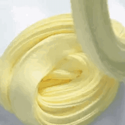 A Close Up Of A Yellow Swirl Of Slime On A Table . GIF