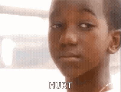 A Close Up Of A Young Boy 'S Face With The Words Hurt Written On It . GIF