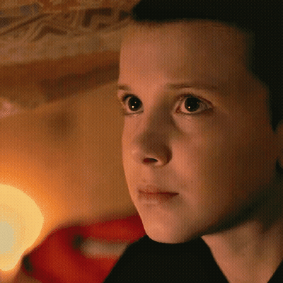 A Close Up Of A Young Girl 'S Face With A Light Behind Her GIF