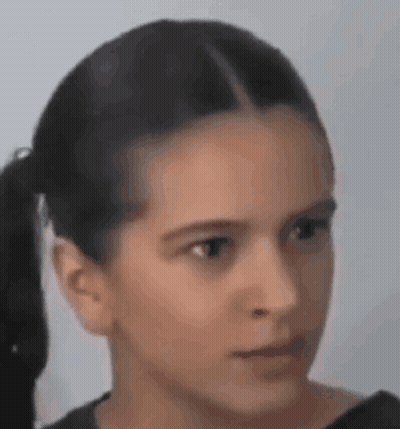 A Close Up Of A Young Girl 'S Face With A Ponytail . GIF
