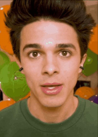 A Close Up Of A Young Man 'S Face In Front Of Balloons GIF