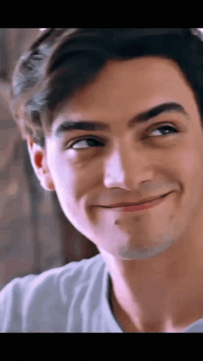 A Close Up Of A Young Man 'S Face Smiling And Looking Up . GIF