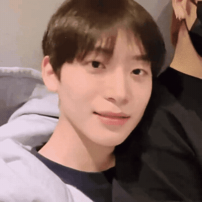 A Close Up Of A Young Man 'S Face Wearing A Black Shirt And A Gray Jacket . GIF