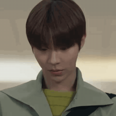 A Close Up Of A Young Man 'S Face Wearing A Green Jacket And A Yellow Sweater . GIF