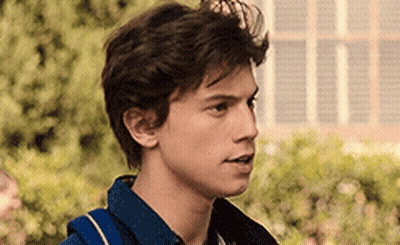 A Close Up Of A Young Man 'S Face With A Backpack On His Back . GIF
